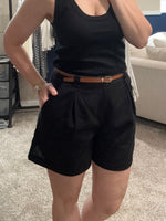 Load image into Gallery viewer, Women's black tank top with black pleated linen shorts and brown belt. 
